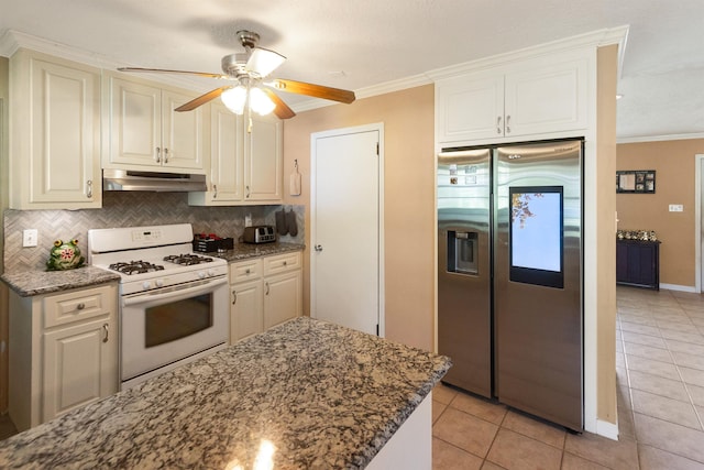 kitchen with crown molding, stainless steel refrigerator with ice dispenser, ceiling fan, light tile patterned floors, and white gas stove