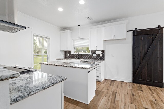 446 Piney Point Dr, Sour Lake, TX 77659 - kitchen with visible vents, a center island, white cabinets, crown molding, and extractor fan