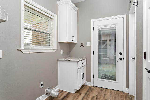 446 Piney Point Dr, Sour Lake, TX 77659 - washroom featuring electric dryer hookup, baseboards, cabinet space, and wood finished floors