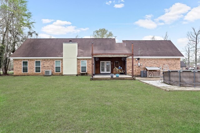 446 Piney Point Dr, Sour Lake, TX 77659 - rear view of property featuring cooling unit, a yard, an outdoor pool, french doors, and brick siding