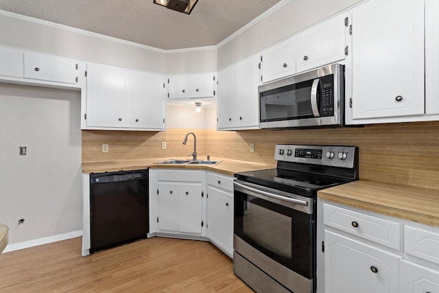 kitchen with sink, a textured ceiling, tasteful backsplash, white cabinetry, and stainless steel appliances