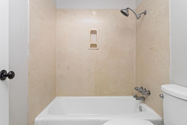 bathroom featuring shower / bathing tub combination and toilet