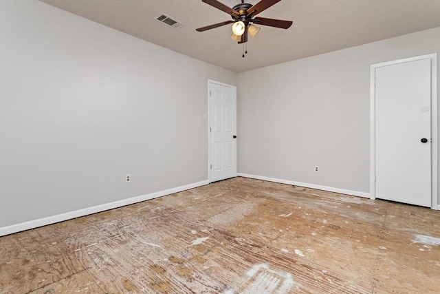 empty room with ceiling fan and a textured ceiling