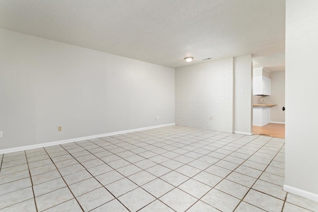 spare room with light tile patterned floors and a textured ceiling