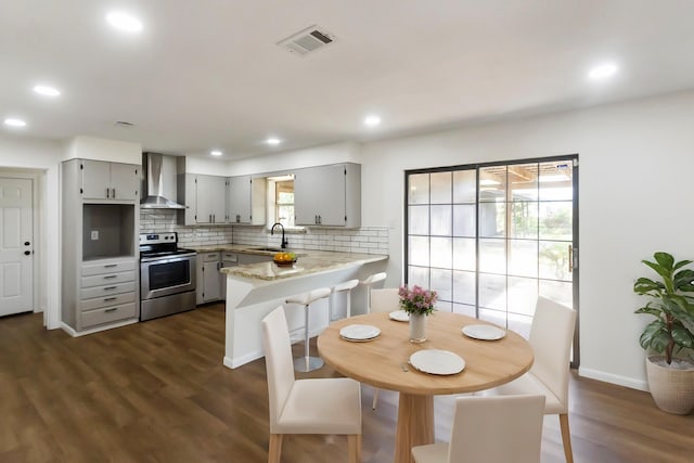 dining space featuring a wealth of natural light, sink, and dark hardwood / wood-style floors