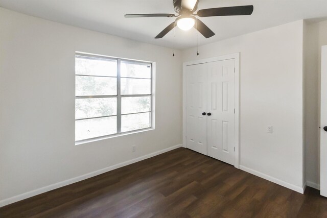 unfurnished bedroom featuring dark hardwood / wood-style flooring, a closet, and ceiling fan