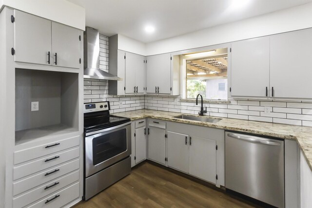 kitchen featuring sink, wall chimney exhaust hood, dark hardwood / wood-style flooring, backsplash, and appliances with stainless steel finishes