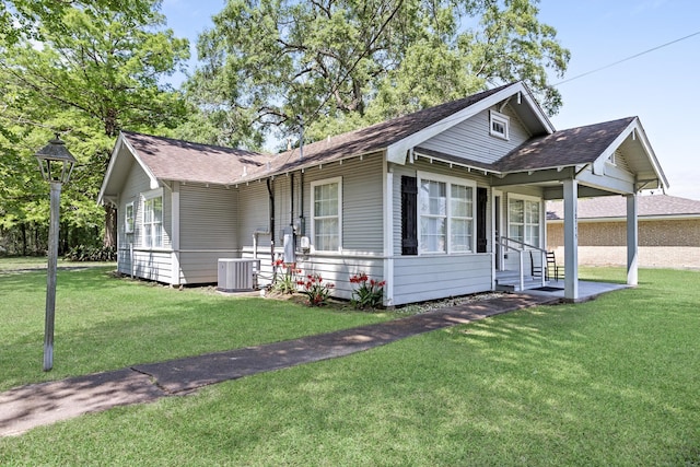 10775 Old Voth Rd, Beaumont, TX 77713 - view of front of home featuring a front yard, a shingled roof, and cooling unit