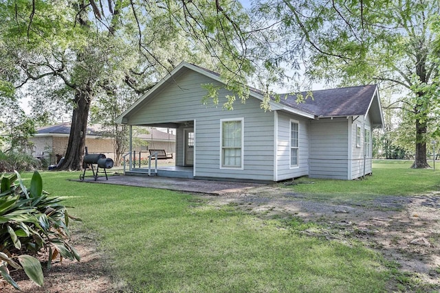 10775 Old Voth Rd, Beaumont, TX 77713 - back of house featuring a patio, a lawn, and a shingled roof