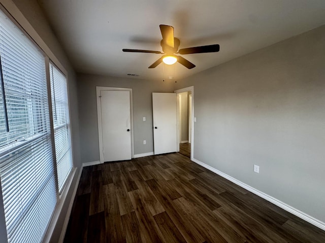 unfurnished bedroom featuring dark wood-type flooring and ceiling fan