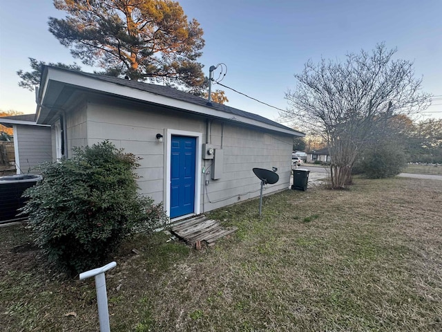 rear view of property featuring a lawn and central air condition unit