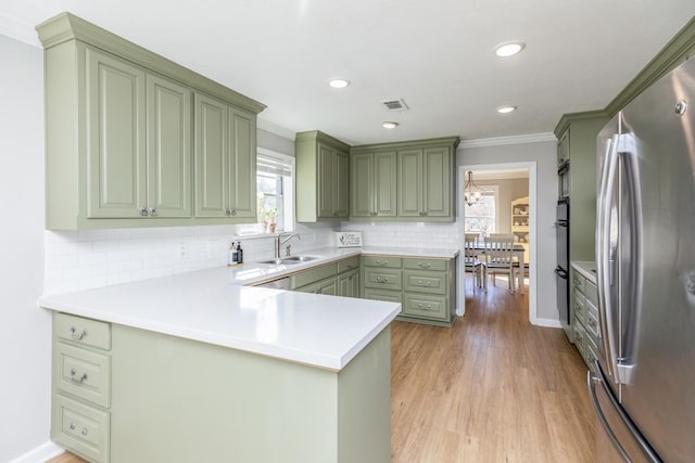 kitchen featuring kitchen peninsula, stainless steel refrigerator, and green cabinetry