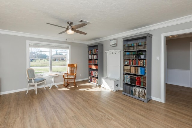 living area with a textured ceiling, light hardwood / wood-style floors, and ornamental molding