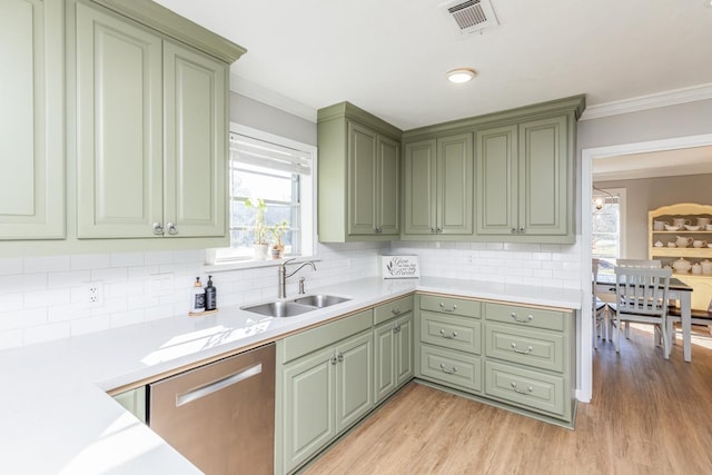 kitchen featuring a wealth of natural light, sink, stainless steel dishwasher, and light hardwood / wood-style flooring