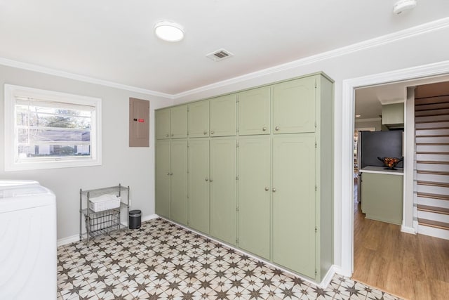 clothes washing area featuring cabinets, electric panel, washer / clothes dryer, and crown molding