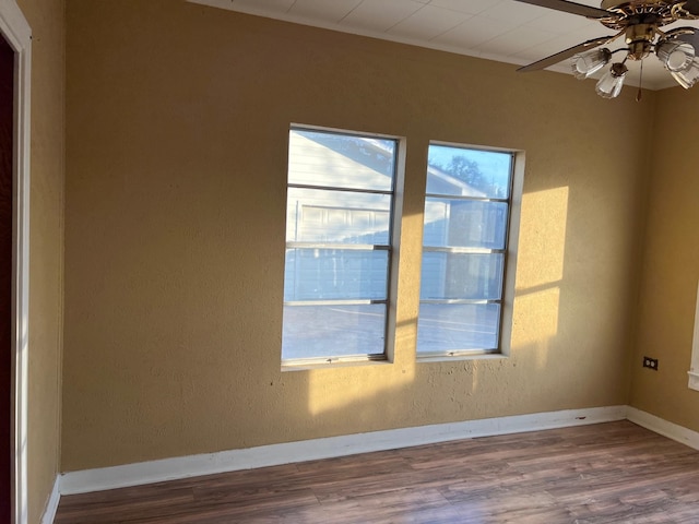 unfurnished room featuring a ceiling fan, baseboards, and wood finished floors