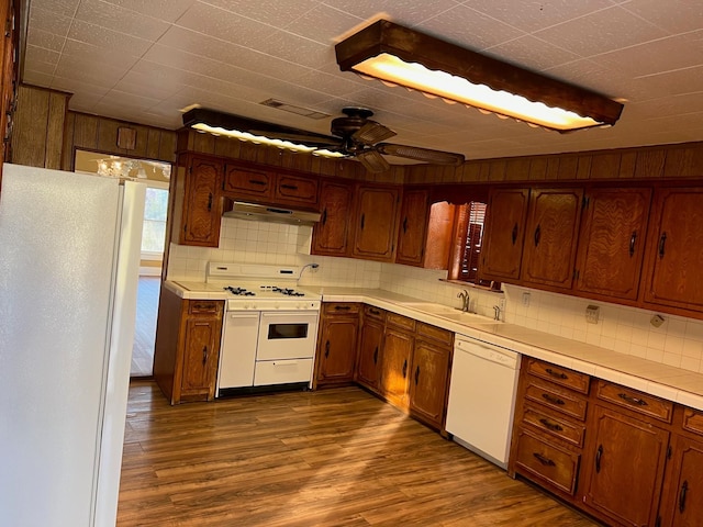 kitchen featuring under cabinet range hood, white appliances, a ceiling fan, light countertops, and dark wood finished floors