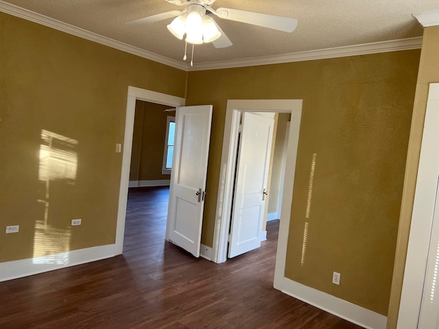 unfurnished room featuring baseboards, a ceiling fan, dark wood-type flooring, a textured ceiling, and crown molding