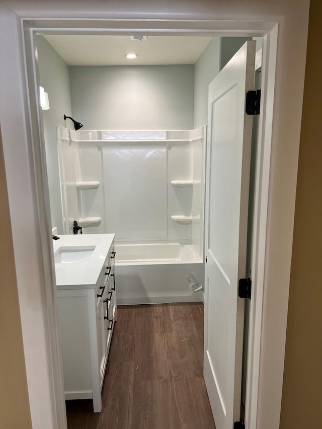 bathroom with tub / shower combination, vanity, and wood finished floors