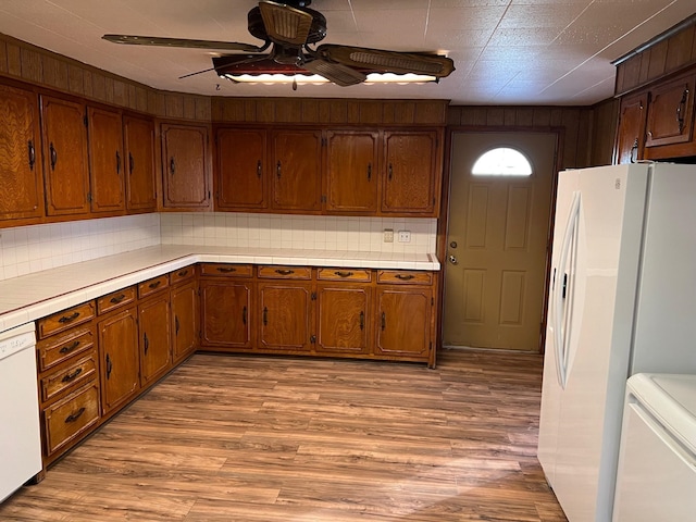 kitchen featuring a ceiling fan, light wood-type flooring, white appliances, and decorative backsplash