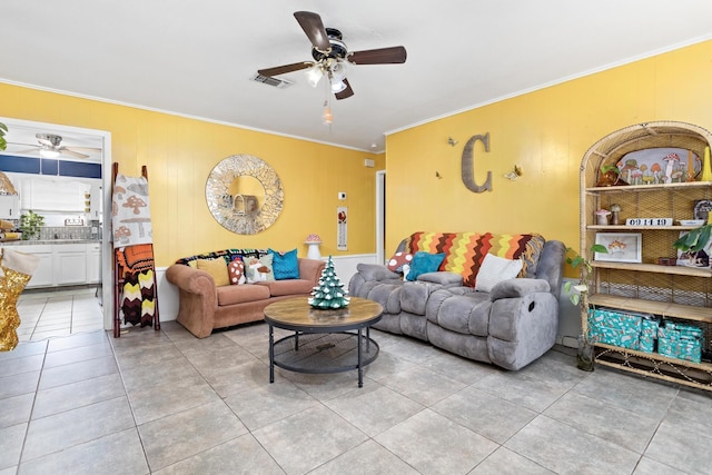 living room with ceiling fan, light tile patterned floors, and crown molding