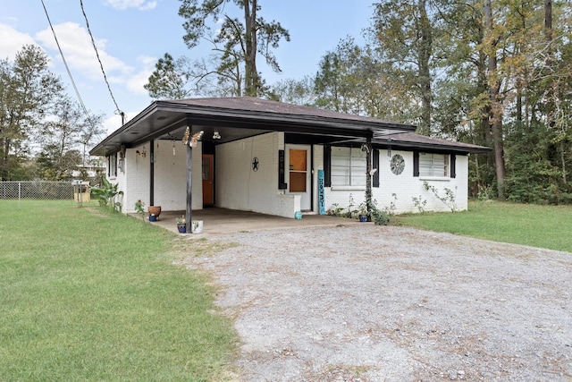 view of front of property with a front lawn and a carport