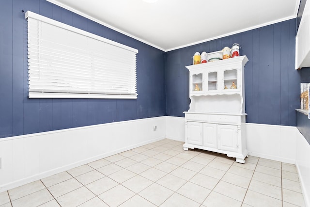 unfurnished room featuring light tile patterned floors and ornamental molding