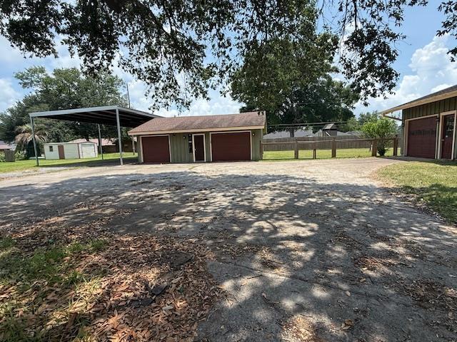 176 Ridgewood St, Bridge City, TX 77611 - garage with asphalt driveway and a detached garage