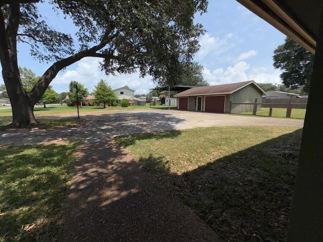 176 Ridgewood St, Bridge City, TX 77611 - view of yard with driveway and a garage