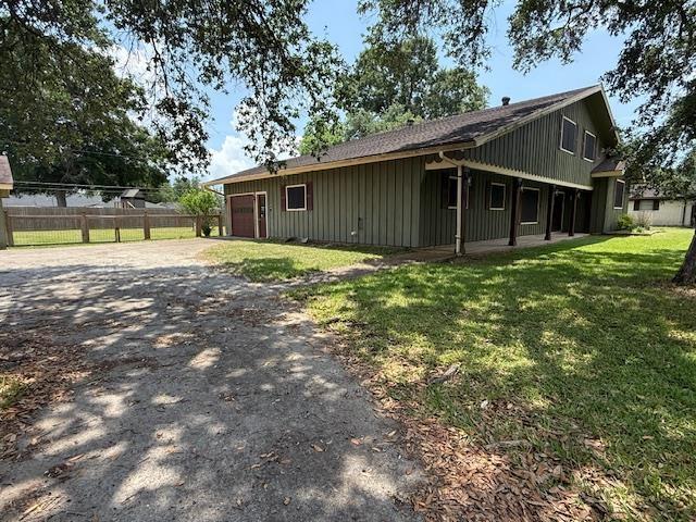176 Ridgewood St, Bridge City, TX 77611 - view of property exterior featuring asphalt driveway, an attached garage, and board and batten siding