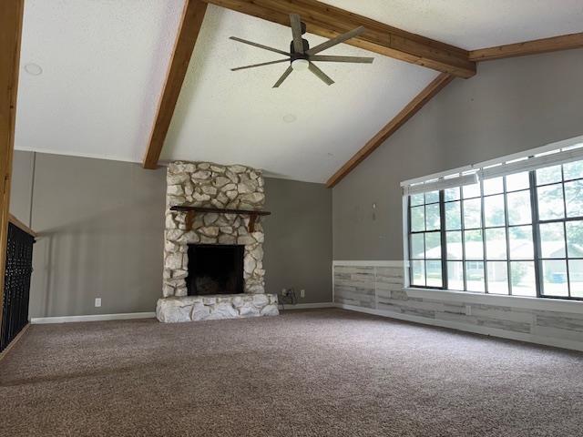 176 Ridgewood St, Bridge City, TX 77611 - unfurnished living room with a stone fireplace, a ceiling fan, beamed ceiling, carpet flooring, and high vaulted ceiling