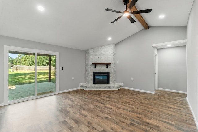 unfurnished living room featuring a fireplace, dark hardwood / wood-style flooring, vaulted ceiling with beams, and ceiling fan