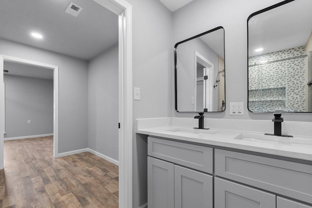 bathroom featuring hardwood / wood-style floors, vanity, and walk in shower