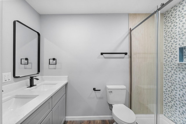 bathroom with hardwood / wood-style floors, vanity, an enclosed shower, and toilet