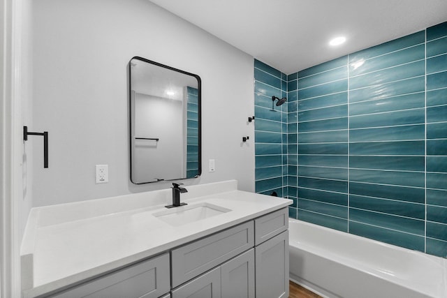 bathroom with tiled shower / bath combo and vanity