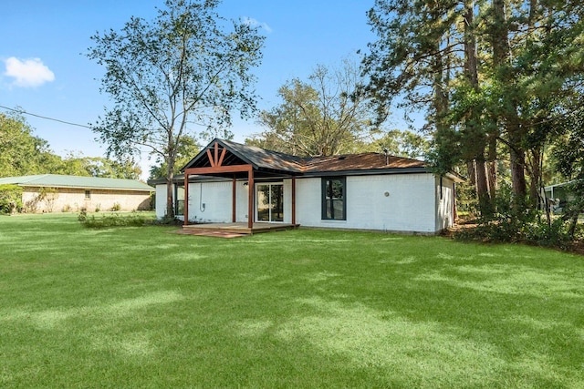 rear view of property with a yard