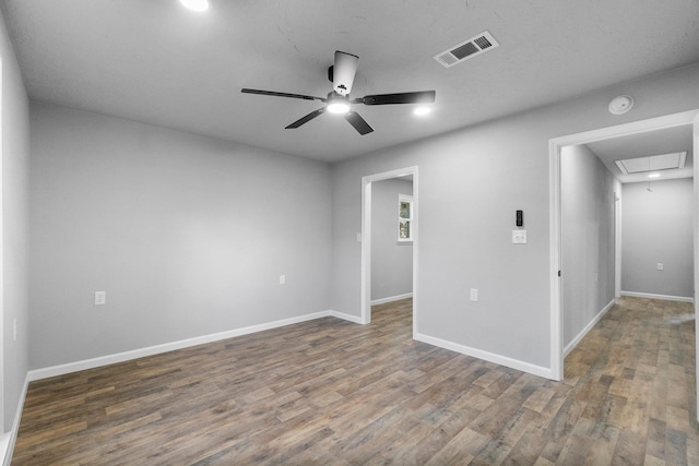 empty room featuring ceiling fan and dark wood-type flooring