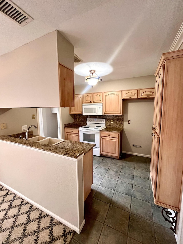 kitchen featuring white appliances, a sink, light brown cabinets, dark countertops, and backsplash