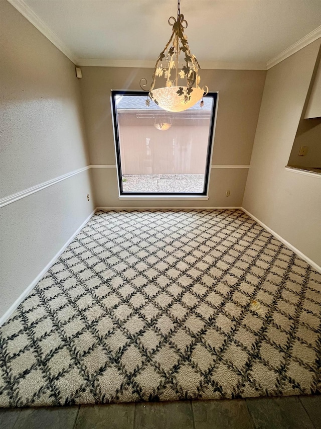 unfurnished dining area with baseboards, ornamental molding, and carpet floors