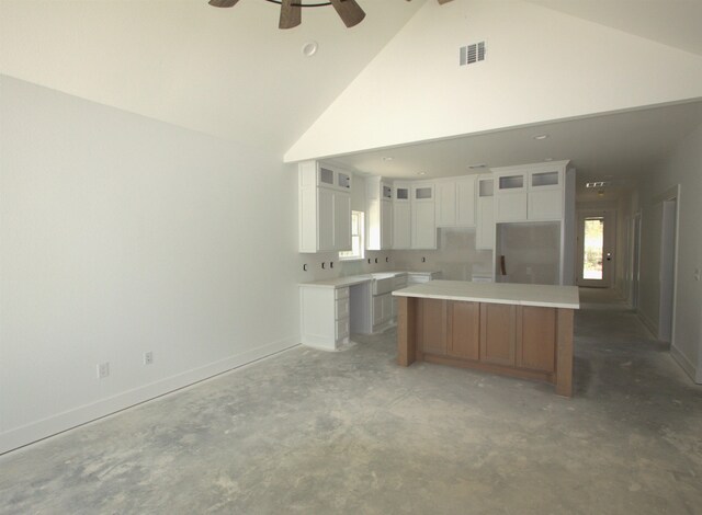 kitchen with appliances with stainless steel finishes, light stone counters, white cabinets, a kitchen island, and hanging light fixtures