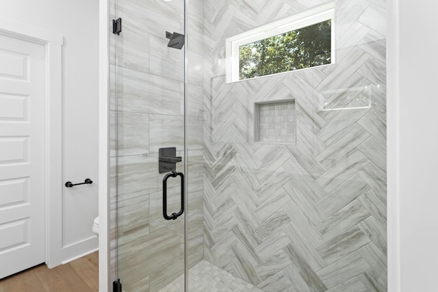 bathroom with an enclosed shower and toilet