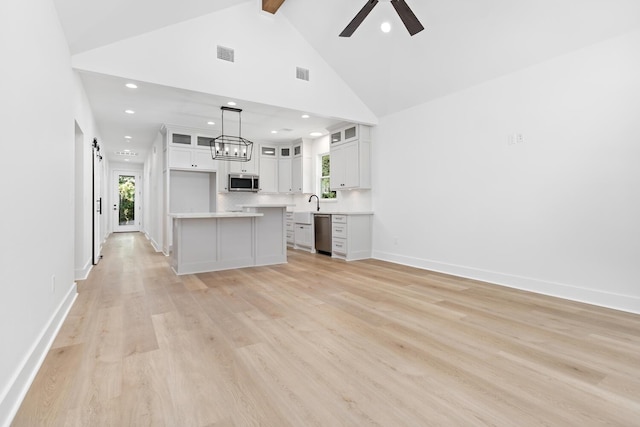 kitchen with pendant lighting, a center island, white cabinets, a wealth of natural light, and appliances with stainless steel finishes