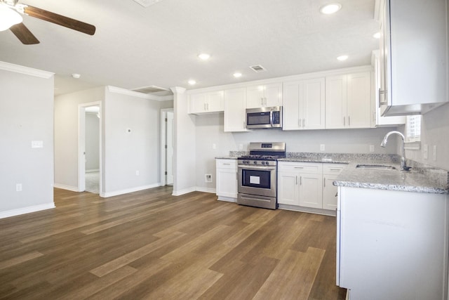 kitchen featuring white cabinets, dark wood-style floors, appliances with stainless steel finishes, and a sink