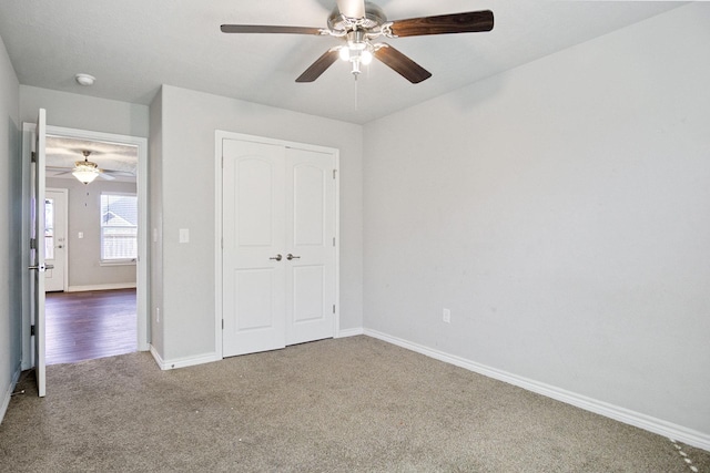 unfurnished bedroom with a closet, carpet floors, baseboards, and ceiling fan