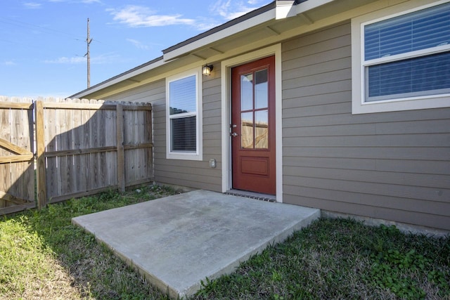 view of exterior entry featuring fence