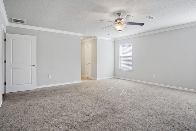 unfurnished room featuring visible vents, carpet flooring, a textured ceiling, and crown molding