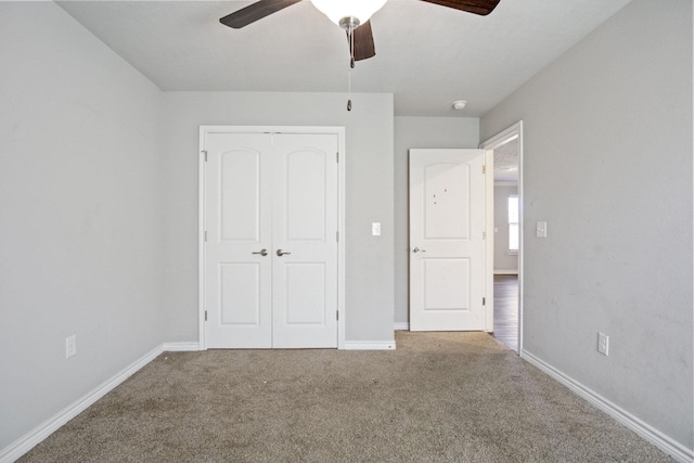 unfurnished bedroom featuring a closet, carpet flooring, a ceiling fan, and baseboards