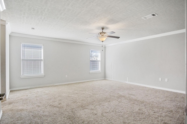 unfurnished room with visible vents, baseboards, ornamental molding, carpet flooring, and a ceiling fan