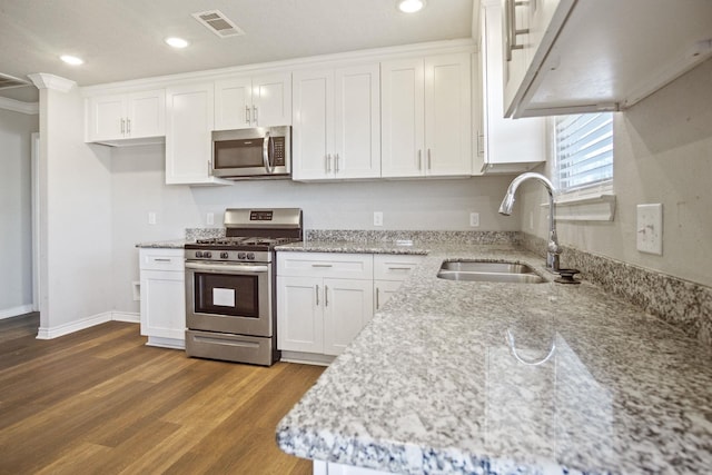 kitchen featuring a sink, stainless steel appliances, visible vents, and white cabinets