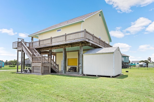 rear view of house featuring a yard, a storage shed, and a wooden deck